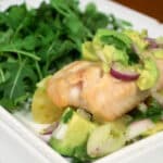 Close up of Tilapia with salsa on a plate.