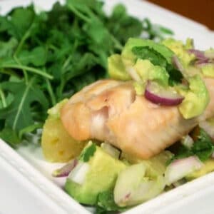 Close up of Tilapia with salsa on a plate.