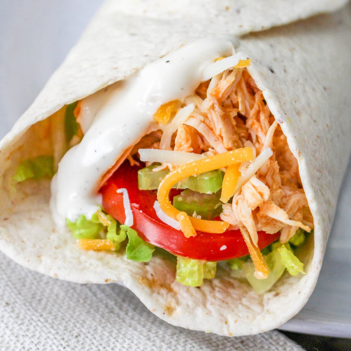 Buffalo Chicken Wrap with ranch dressing, cheese, tomatoes, and celery.