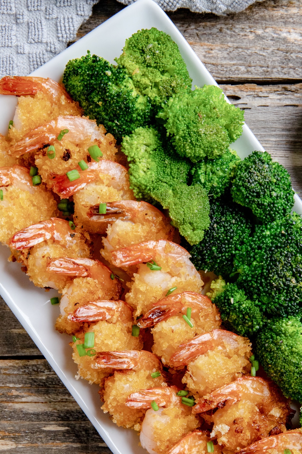 Breaded Sriracha Shrimp on a platter with broccoli.