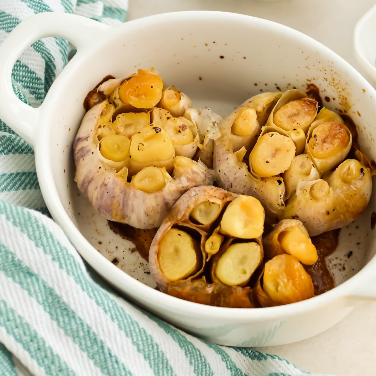 Three heads of Roasted Garlic in a baking dish.