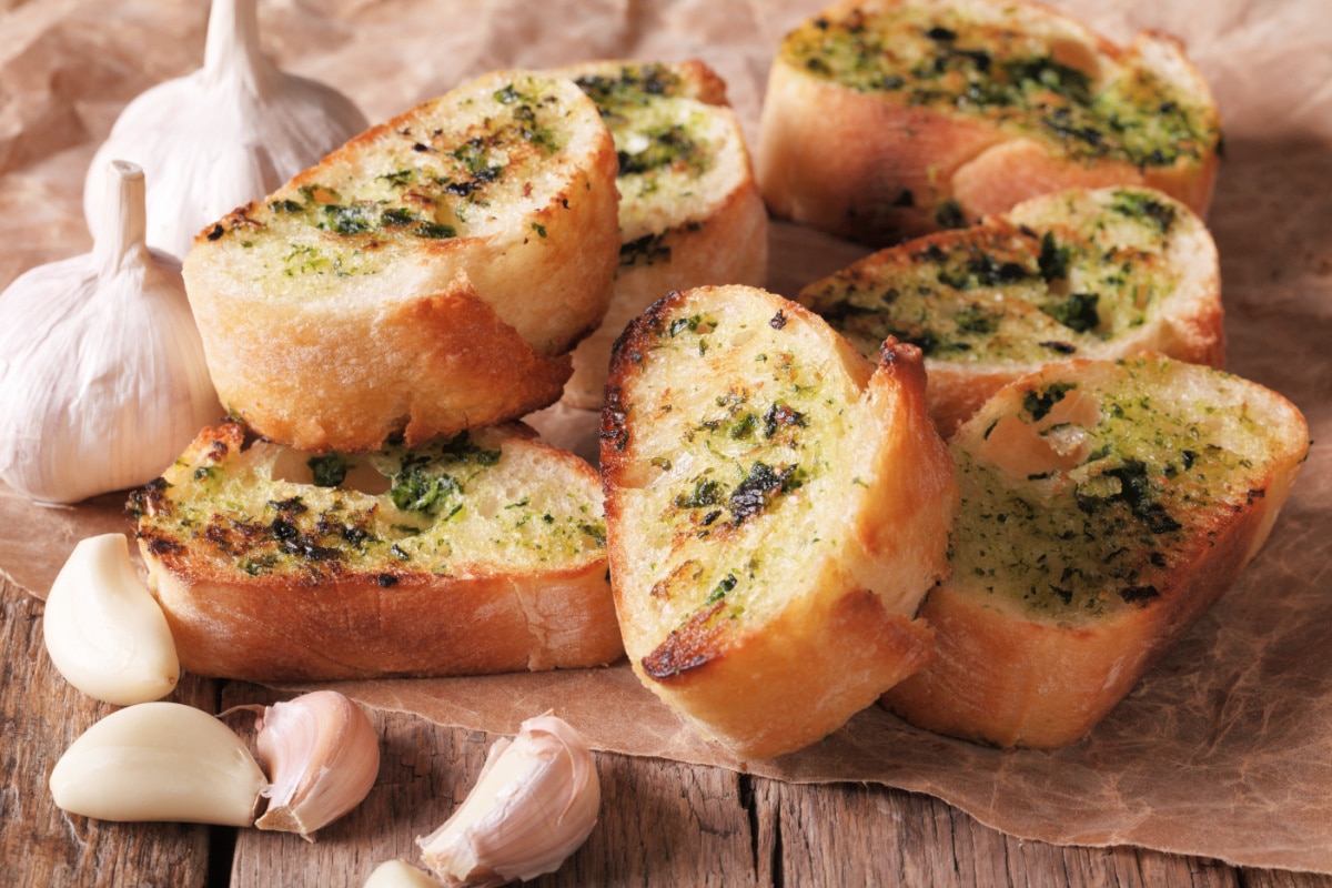Garlic bread with compound butter on parchment paper.