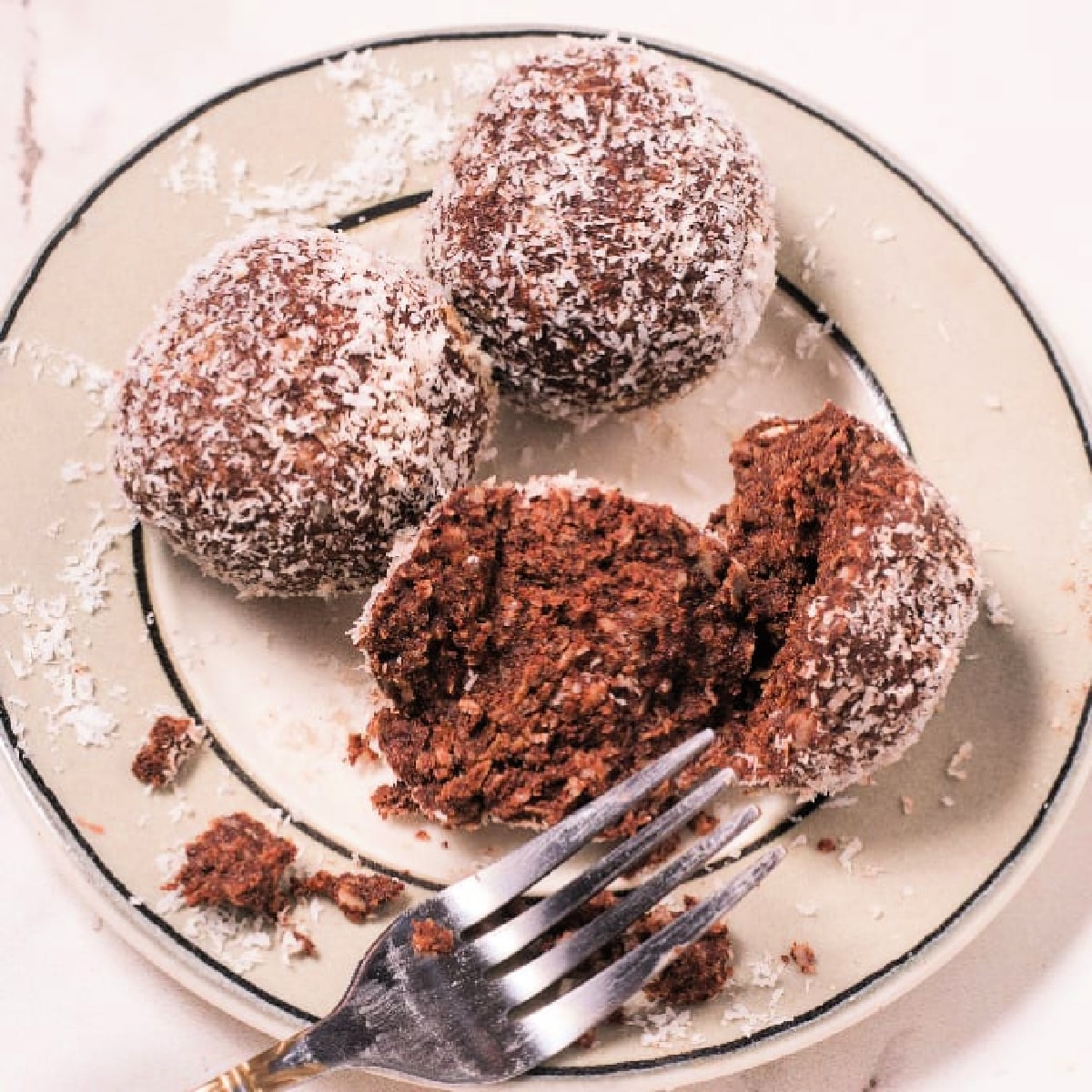 Coconut Energy Balls with Chocolate on a plate with a fork.