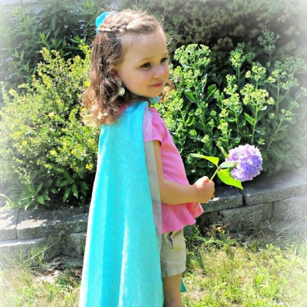 Little girl models DIY Elsa's Cape from Disney's Frozen.