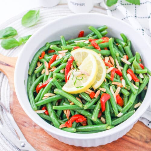 Italian Green Bean Salad in a bowl garnished with lemon.
