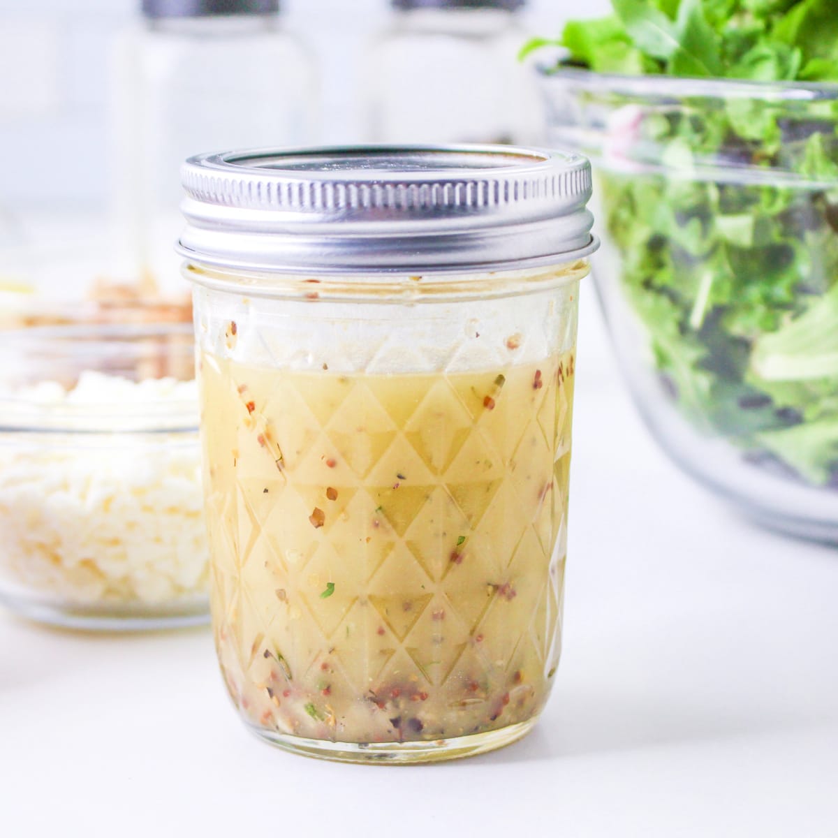 Lemon and mustard vinaigrette in a mason jar with a lid.