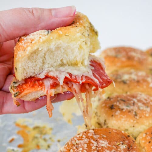 Hand holding a Pepperoni and Cheese Pizza Slider.
