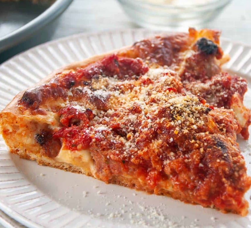 Slice of Chicago Deep Dish Pizza on a white plate.