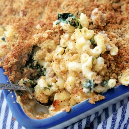 Italian Sausage Macaroni and Cheese in a baking dish with a spoon.
