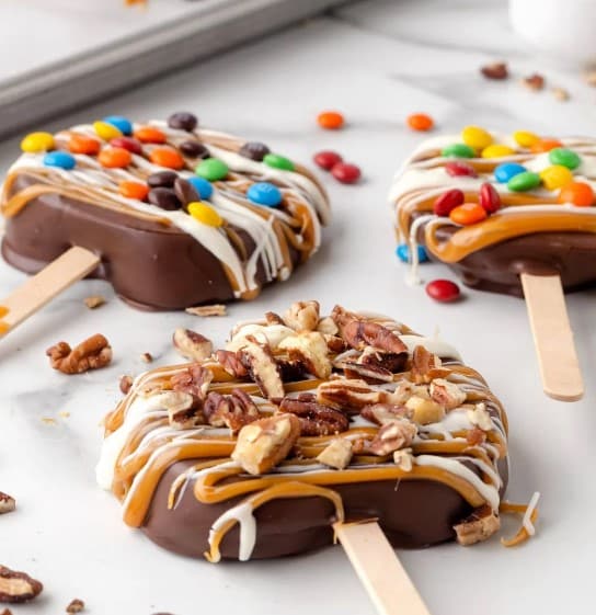 Chocolate Covered Caramel Apple Slices with candies.