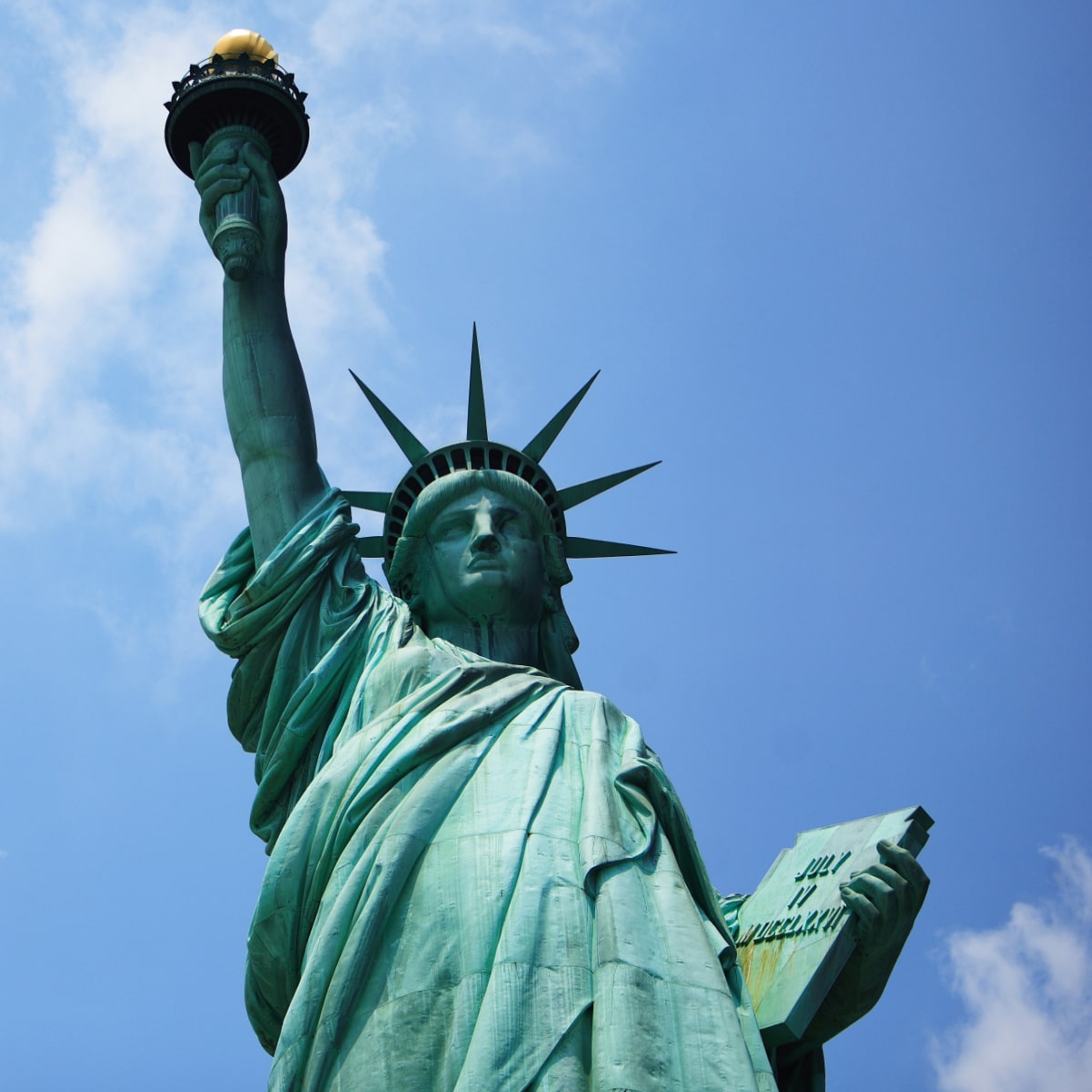 Looking up at the Statue of Liberty on a sunny day.