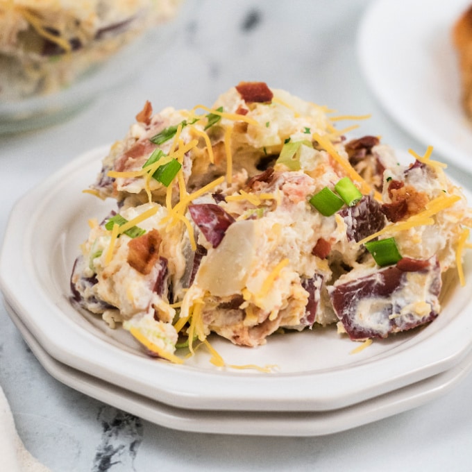Potato salad with bacon and green onions on a plate.