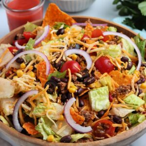 Close up of Taco Salad with Doritos in a wooden bowl.