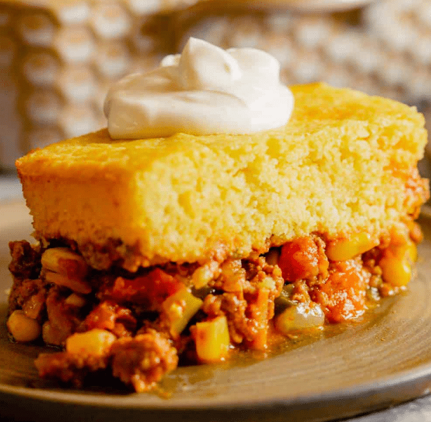 Tamale Pie with a dollop of sour cream on a plate.