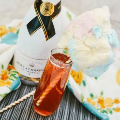 Cotton Candy Kir Royale in champagne flute with cotton candy.
