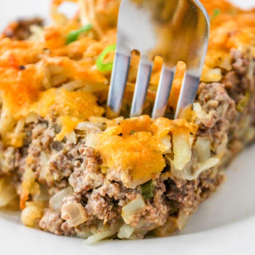 Close up of a fork in Hashbrown and Ground Beef Casserole.