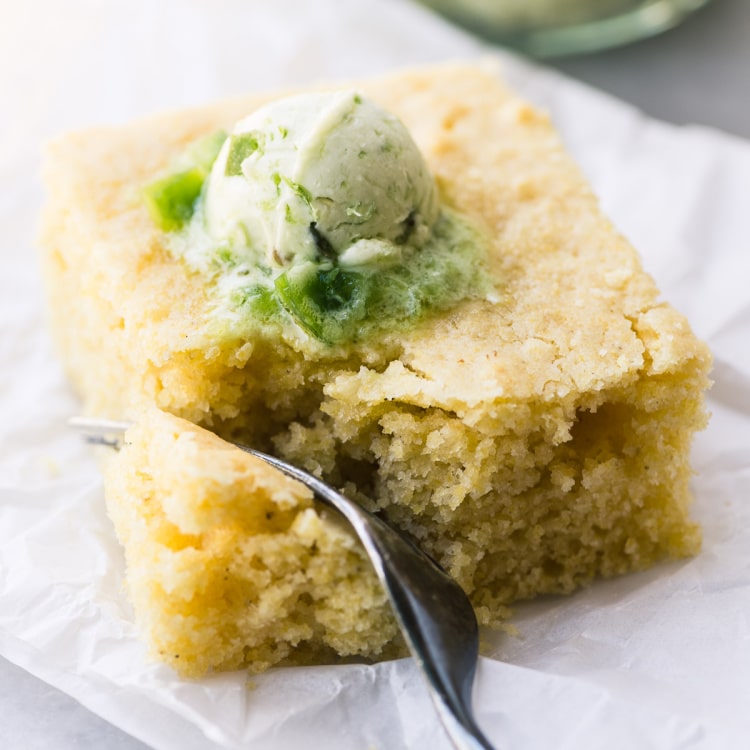Square of cornbread with jalapeno butter on top.