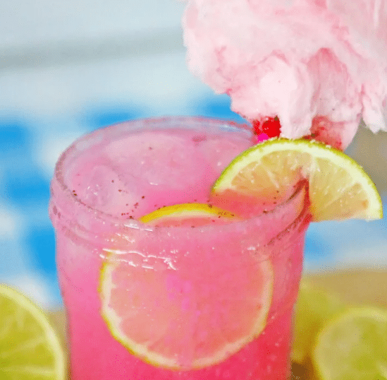 Close up of Cotton Candy Margarita with slices of lemon and lime.