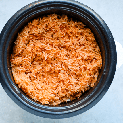Top down view of a rice cooker pot with Mexican rice.