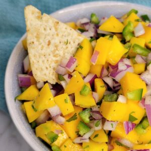 Close up of mango salasa with a tortilla chip.