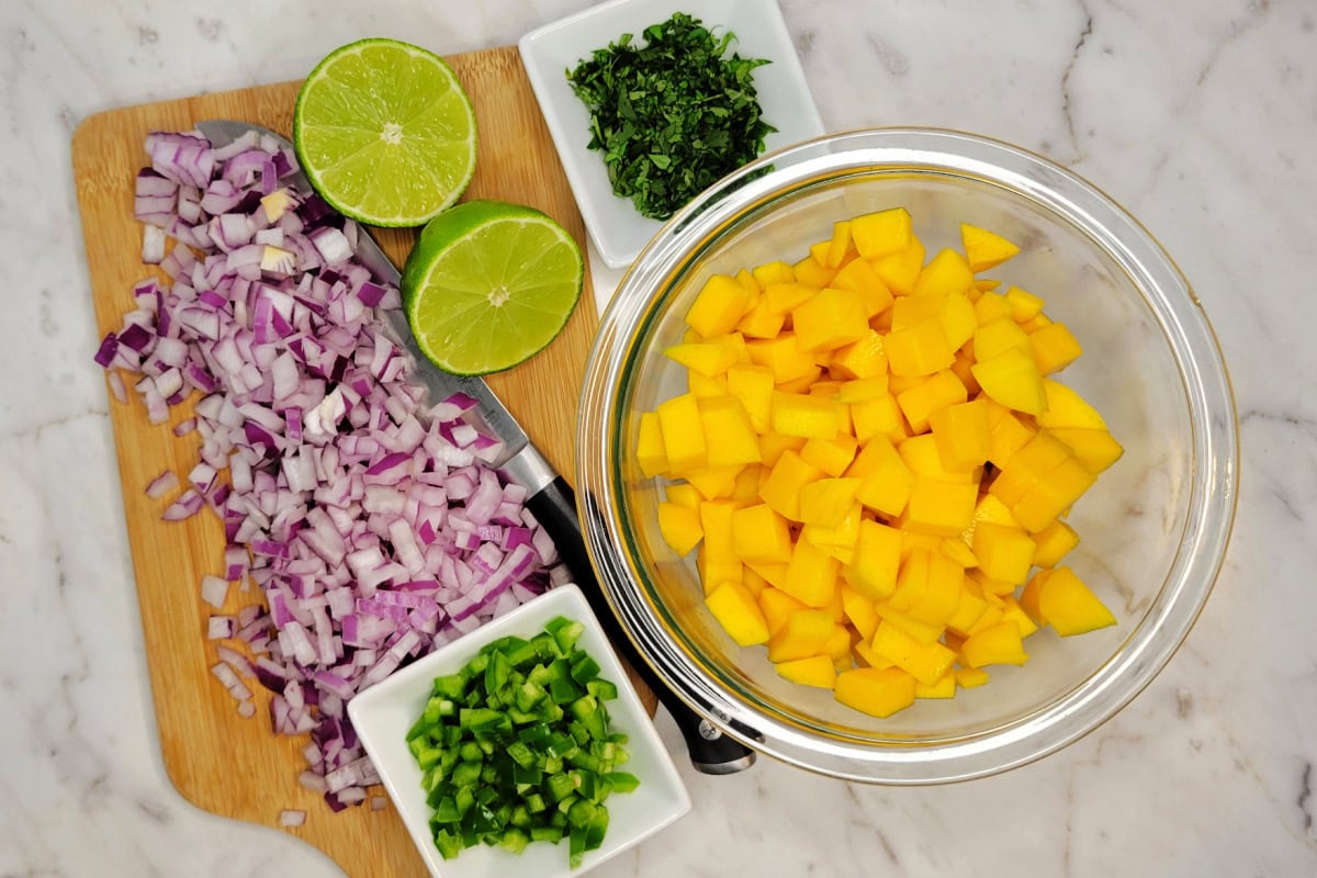 Mise en place Mango Salsa Ingredients including red onions, jalapeno, and cilantro.