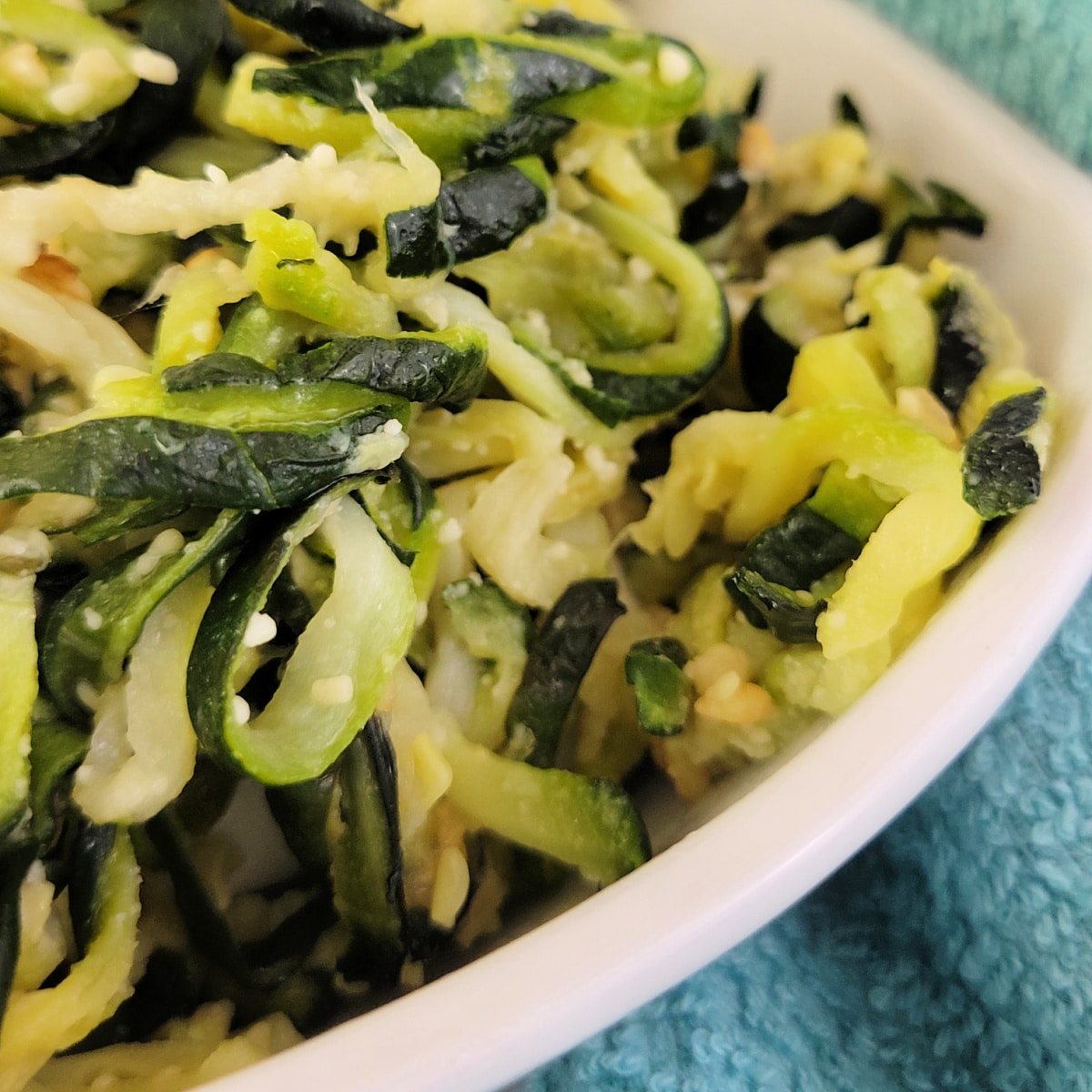 Close up of zucchini noodles with garlic and parmesan cheese.