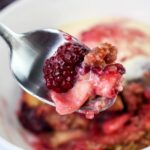 Close up of Apple Blackberry Crumble on a spoon.