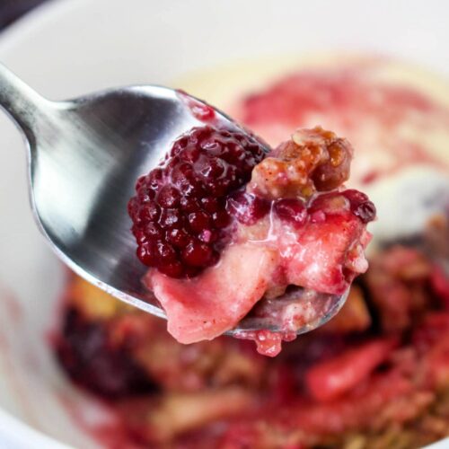 Close up of Apple Blackberry Crumble on a spoon.