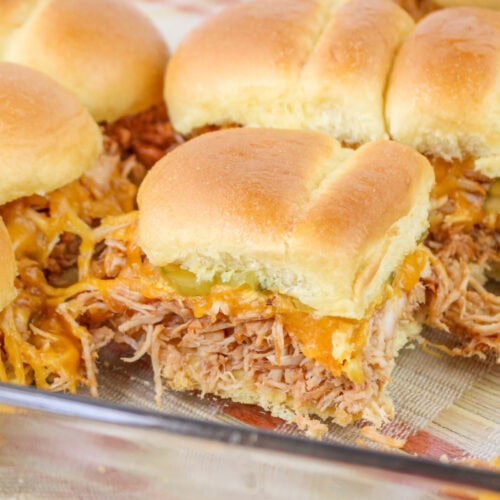 Close up of Barbecue Chicken Sliders topped with cheese and pickles.