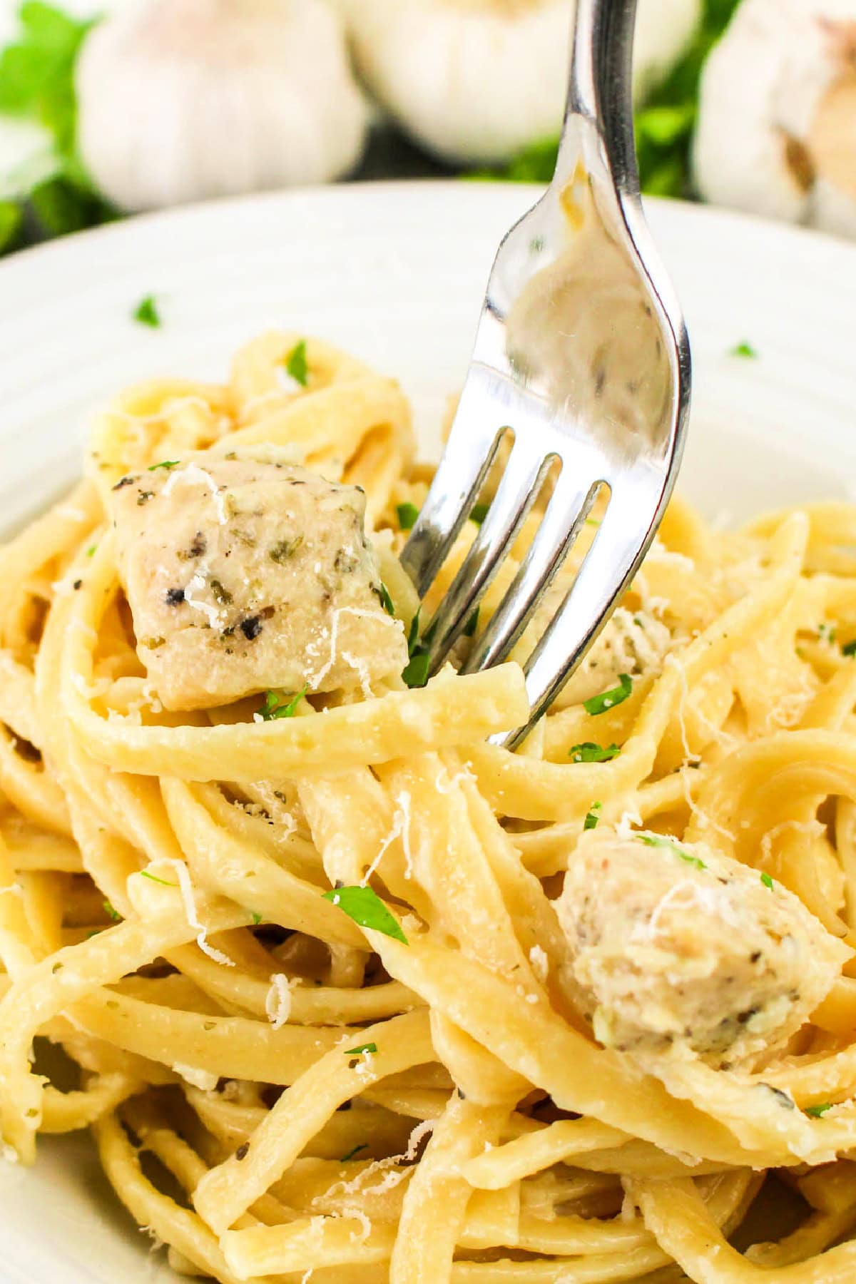 A fork and Garlic Parmesan Chicken Pasta on a plate.