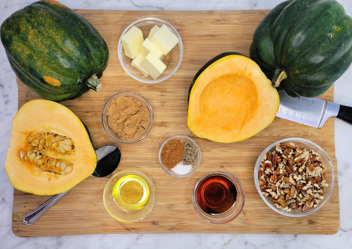 Ingredients in bowls to make Acorn Squash on a cutting board with a chefs knife and spoon.