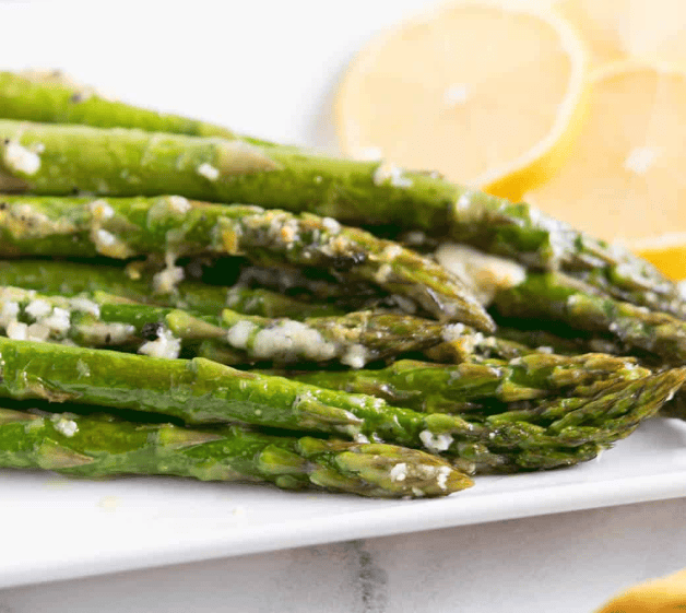 Slow Cooker Thanksgiving Recipes: aspararugs with parmesan and lemons on a plate.