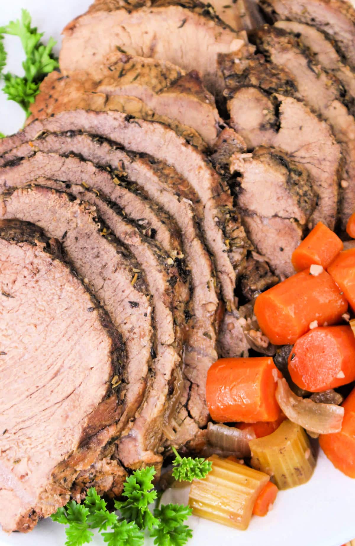 Slow Cooker Sirloin Tip Roast Beef on a platter with vegetables.