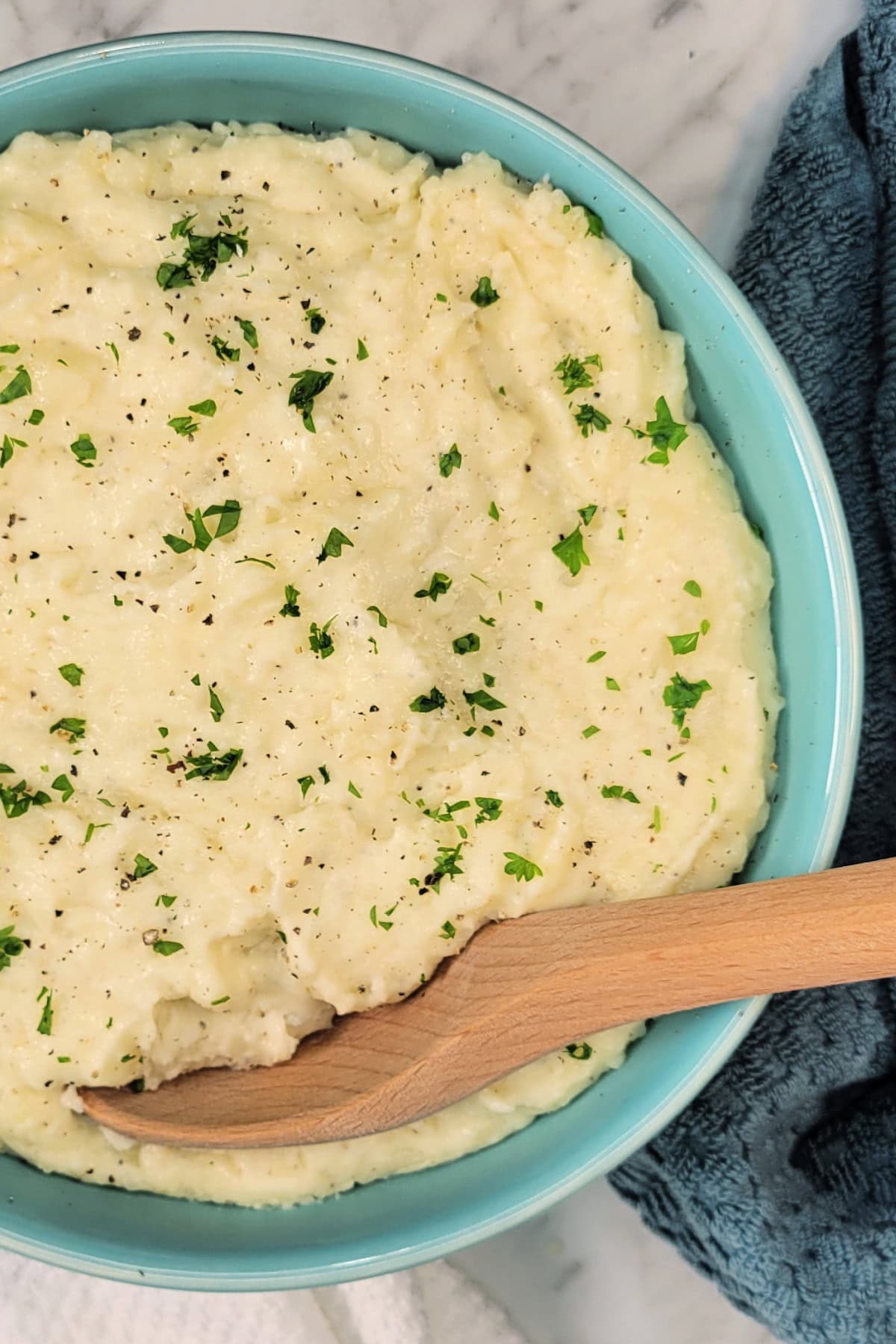 Creamy Mashed Potatoes with white cheddar, sour cream, and heavy cream in a serving bowl.