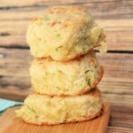 Close up of Stack of cheddar jalapeno biscuits on a cutting board.