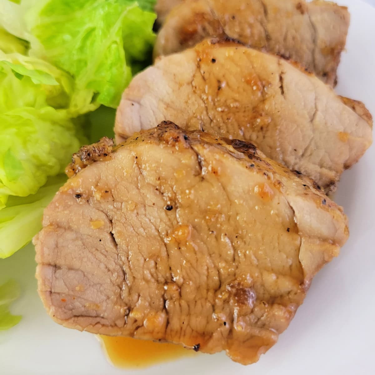Close up of pork tenderloin with honey garlic sauce.