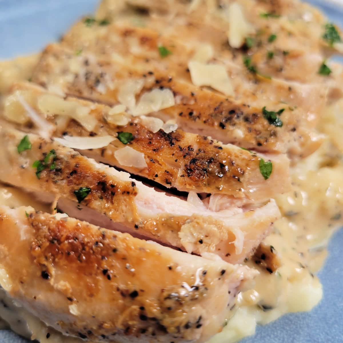 Close up of sliced chicken with Garlic Parmesan Sauce.