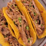 Close up of Crock pot Shredded Beef Tacos with corn tortillas.
