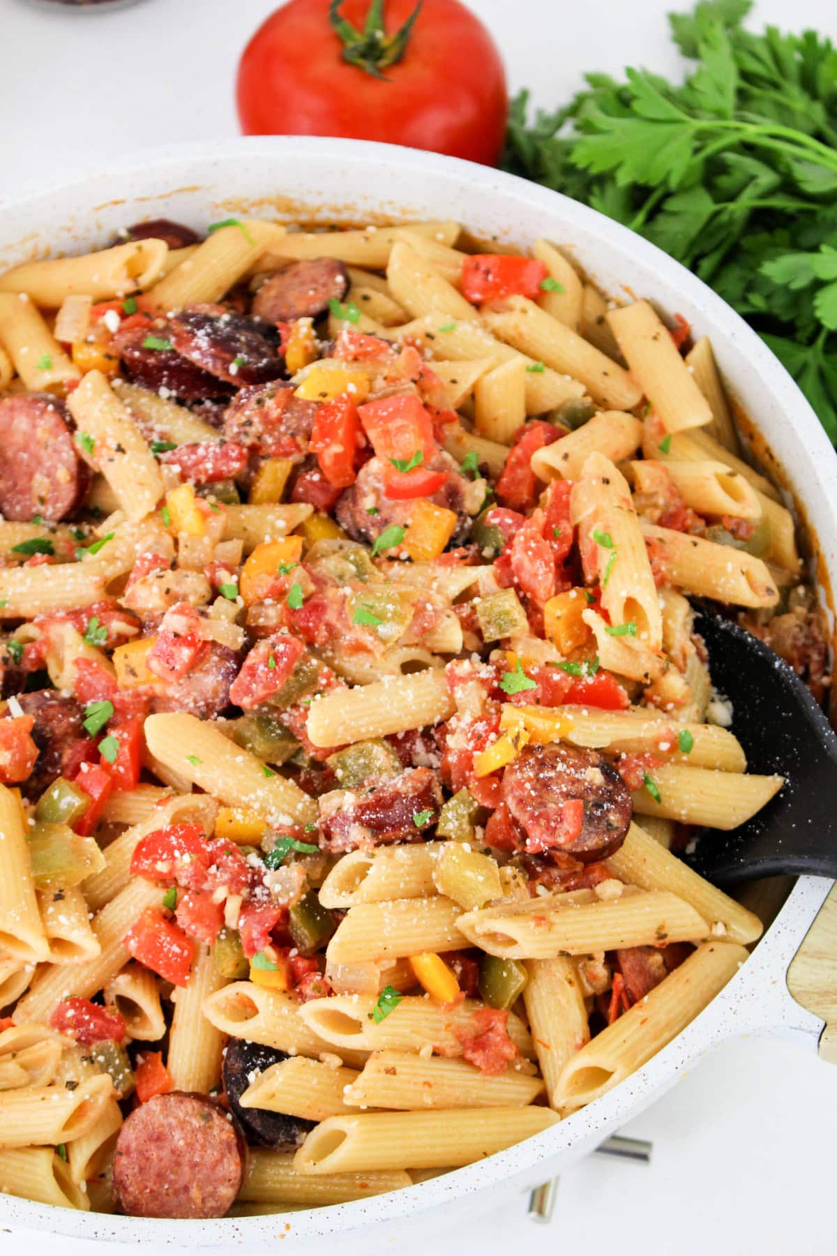 Creamy Smoked Sausage Pasta skillet meal with a serving spoon.