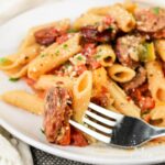 Close up of Smoked Sausage Pasta on a plate with a fork.