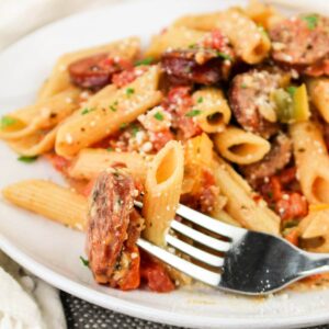 Close up of Smoked Sausage Pasta on a plate with a fork.